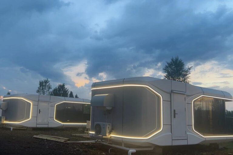 A couple of white trailers sitting next to each other.