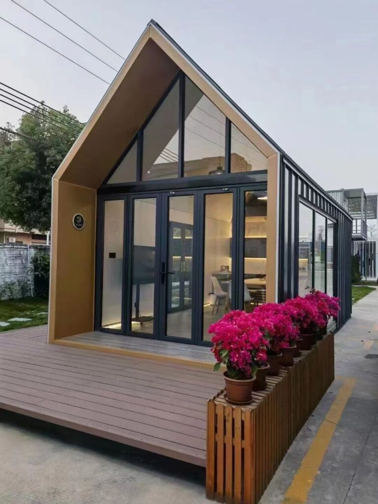 A small house with a large porch and flower pots.